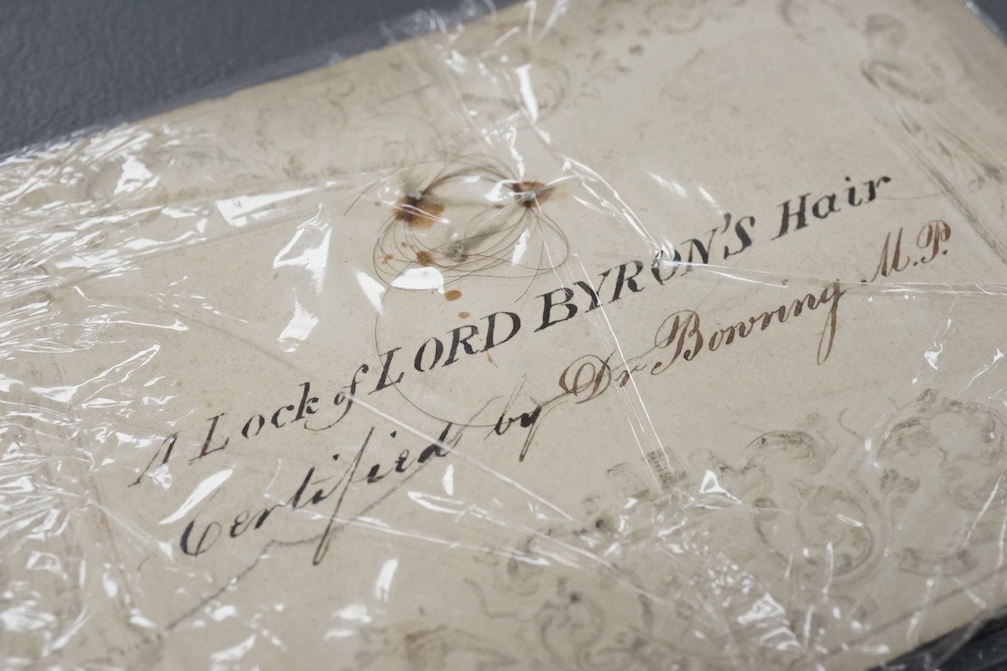 A lock of Lord Byron's hair mounted on an early 19th century embossed card decorated with classical figures, 11.3 x 7.5cm, stamped ‘Beilby & Knotts’, with a contemporary handwritten description stating; ‘A Lock of Lord B